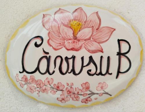 a sign with a pink flower on a wall at U Càvusu in Siculiana