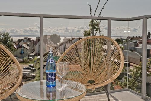 a bottle of soda sitting on a table with a wine glass at Casa Baia BlueApart Hel in Hel