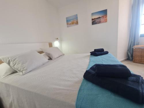 Una cama blanca con una manta azul encima. en Casa Armando, en Costa de Antigua