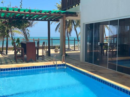 a swimming pool with a view of the ocean at Muriú RN - Savage Beach House in Ceará-Mirim