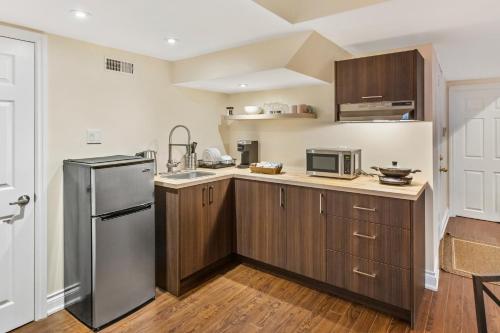 a kitchen with wooden cabinets and a stainless steel refrigerator at Cozy 1-BR, with Private Patio in Vaughan