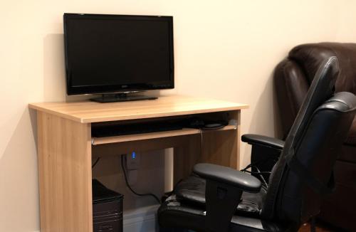 a television sitting on a wooden table with a chair at Cozy 1-BR, with Private Patio in Vaughan
