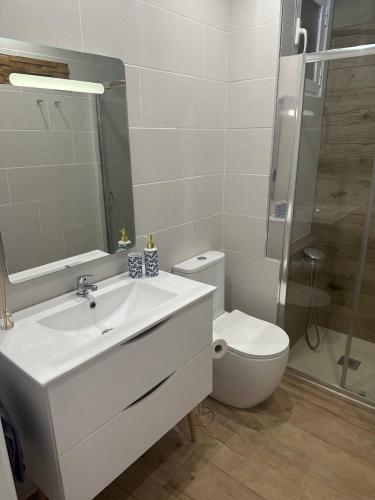 a bathroom with a white sink and a toilet at Seashell apartment in Cullera in Cullera