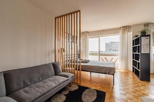 a living room with a couch and a bed at T1 Confort Tête d'Or Doua - Parking Gratuit in Villeurbanne