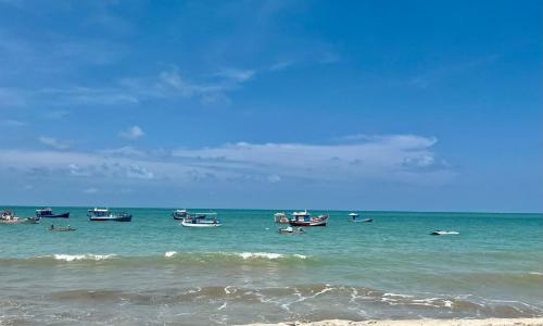 a group of boats in the water on a beach at Muriú RN - Savage Beach House in Ceará-Mirim