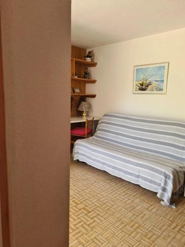 une chambre avec un lit avec un tableau sur le mur dans l'établissement Appartement cosy à Port Leucate 44 m² avec terrasse et jardin, à Port-Leucate