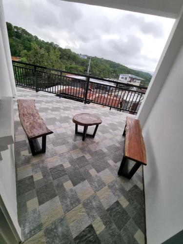 two benches and a table on a balcony at Trail Bedz Homestay in Baguio
