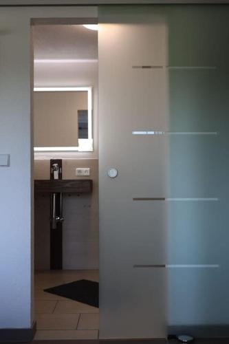 a hallway with a bathroom with a mirror and a counter at Weingut Lahmer August Appartment Rebstock in Kretzschau