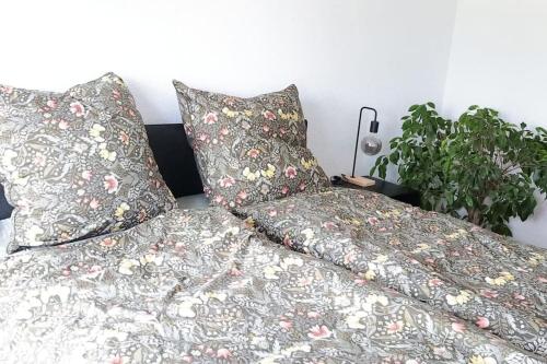 a bed with two pillows sitting next to a plant at Weingut Lahmer August Appartment Rebstock in Kretzschau