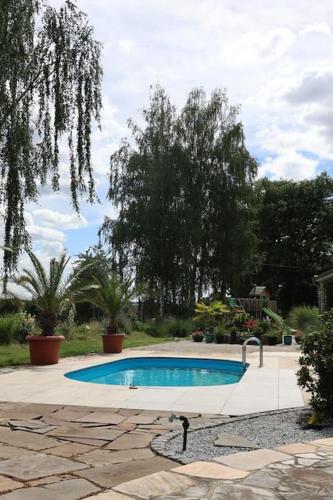 a small swimming pool in a yard with trees at Weingut Lahmer August Appartment Rebstock in Kretzschau