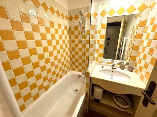 une salle de bain avec un lavabo, une baignoire et un miroir dans l'établissement 4 people with Pool Tennis Parking air cond, à Cannes