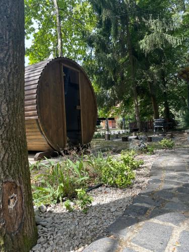 a wooden tub sitting next to a tree at Mókus Vendégház in Doboz