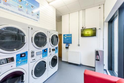 two washing machines in a laundry room with a tv at Destiny Student – Shrubhill (Campus Accommodation) in Edinburgh