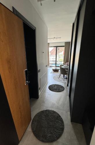 a room with a door and two rugs on the floor at Penthouse Apartman Bulevar Sarajevo in Sarajevo