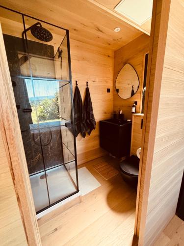 une salle de bain avec une douche avec une porte vitrée dans l'établissement La Cabane de Pierrot, à Saint-Bonnet-le-Courreau