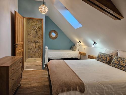 - une chambre avec 2 lits et une porte avec un miroir dans l'établissement Confidences Escale à Brissac, à Brissac-Quincé