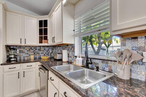 a kitchen with a sink and a window at Hottub! Mini Golf! Water Access! Pets! 5min beach! in West Palm Beach