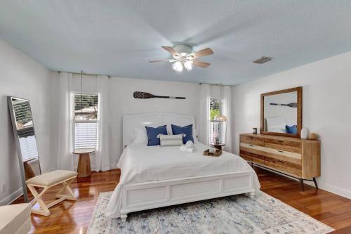 a bedroom with a white bed and a ceiling fan at Hottub! Mini Golf! Water Access! Pets! 5min beach! in West Palm Beach
