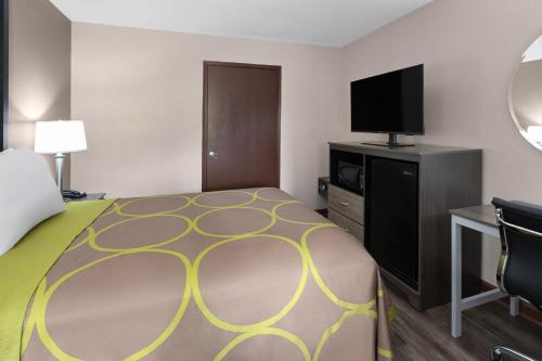 a hotel room with a bed and a flat screen tv at Super 8 by Wyndham Bridgeport/Clarksburg Area in Bridgeport