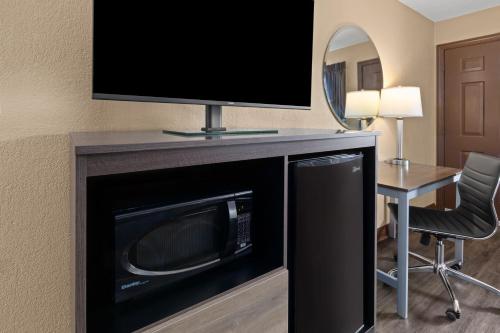 a living room with a television on top of a microwave at Super 8 by Wyndham Bridgeport/Clarksburg Area in Bridgeport