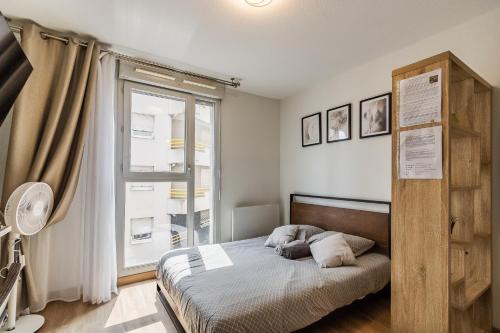 une chambre avec un lit et une fenêtre dans l'établissement Studio Charpennes - Parking privé gratuit, à Villeurbanne