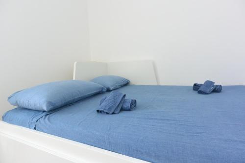a bed with blue sheets and pillows on it at Felix House in Savona
