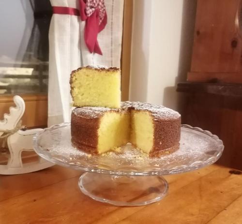 a cake on a glass plate on a table at B&B Sass de Mura in Fiera di Primiero