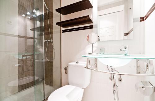 y baño con aseo, lavabo y ducha. en Gran Via III, en Madrid