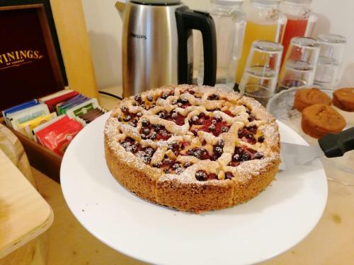 a cake sitting on a white plate on a table at B&B Sass de Mura in Fiera di Primiero