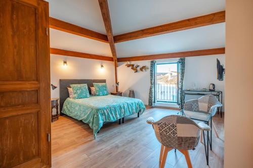 une chambre avec un lit, une table et une chaise dans l'établissement Les Greniers Du Château, à Domazan