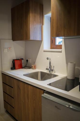 a kitchen with a sink and wooden cabinets at AROMA DRYOS in Kato Drys