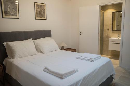 a bedroom with a white bed with two towels on it at AROMA DRYOS in Kato Drys