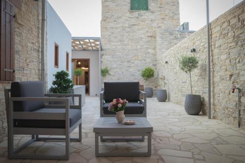 a patio with two chairs and a table with flowers at AROMA DRYOS in Kato Drys