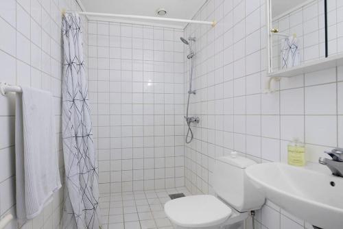 une salle de bain carrelée blanche avec toilettes et lavabo dans l'établissement Forus - ONS, à Stavanger