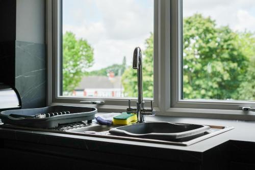 a kitchen counter with a sink and a window at The Olive Tree Aparthotel in Hull