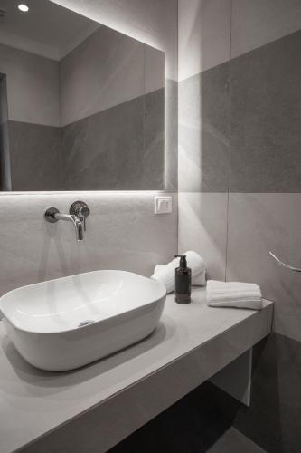 a bathroom with a white sink and a mirror at Alexander House Hotel in San Ferdinando