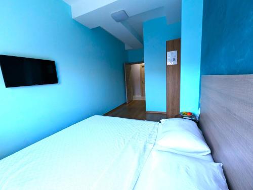 a blue room with a bed and a flat screen tv at Easy Apartments in Kumanovo