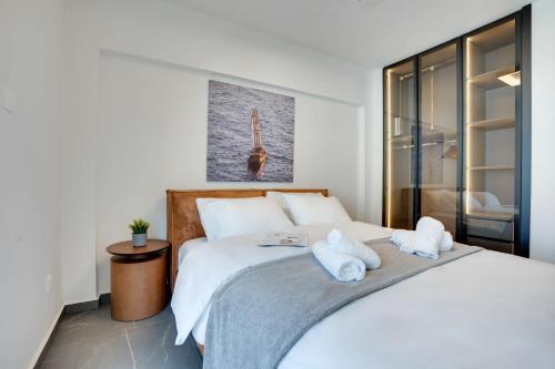a bedroom with a large white bed with towels on it at Sea Front Luxury Apartment in Oroklini