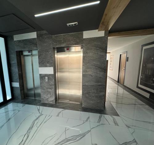a lobby with a elevator in a building with marble floors at Penthouse Apartman Bulevar Sarajevo in Sarajevo