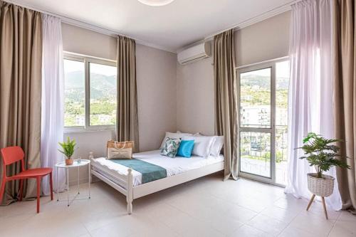 a bedroom with a bed and two windows at Himara City 33 - Central, Beach Access in Himare