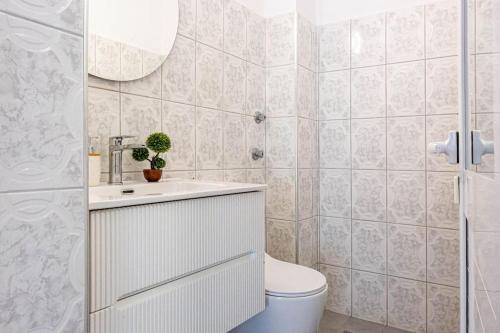 a bathroom with a toilet and a sink and a mirror at Himara City 33 - Central, Beach Access in Himare