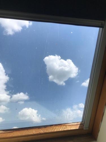 une fenêtre avec un nuage dans le ciel dans l'établissement STUDIO 63M2 3EME ETAGE OU CHAMBRE DANS APPARTEMENT 2EME ETAGE pour SEJOURS A MOULINS, à Moulins