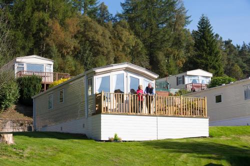 a group of people standing on the deck of a tiny house at Corriefodly Holiday Park in Blairgowrie