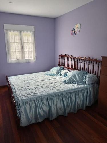 a bedroom with a large bed with blue walls at Casa independiente Solana in O Lourido
