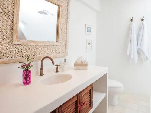 une salle de bain blanche avec un lavabo et un miroir dans l'établissement Isla Pelícano, à Isla Grande