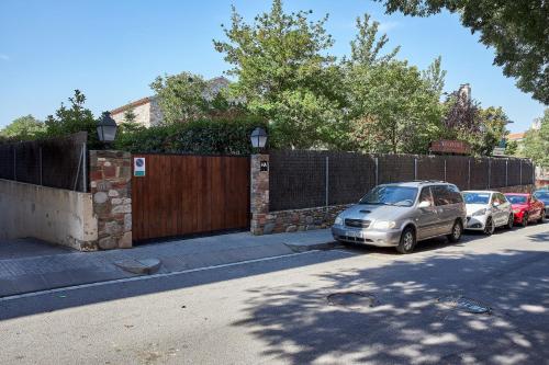 a couple of cars parked next to a fence at Mas Can Calet Aparthotel in Les Franqueses del Vallès