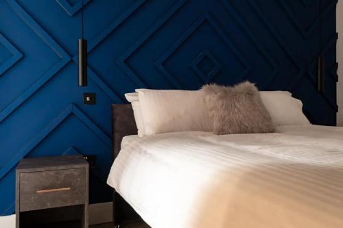 a bedroom with a blue wall with a bed at The Oak Barn in Southampton