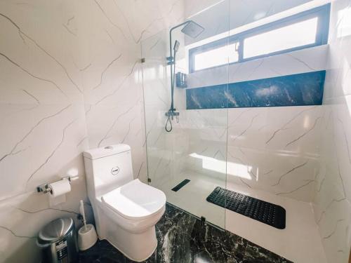 a white bathroom with a toilet and a shower at Villa luxury Kerry Residence 02 in Punta Cana