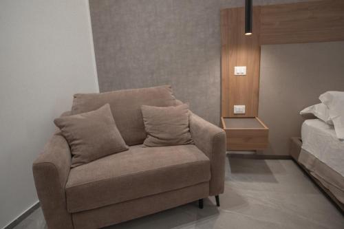 a couch with two pillows on it in a bedroom at Alexander House Hotel in San Ferdinando