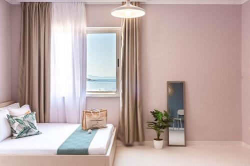 Un dormitorio con una cama con una ventana grande. en Himara City 34 - Central & Beach Access, en Himare